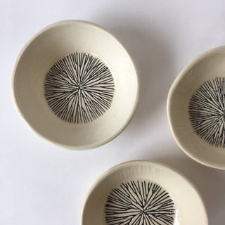 Three ceramic bowls with black abstract patterns on a white background
