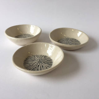 Three ceramic bowls with black patterns on a white background