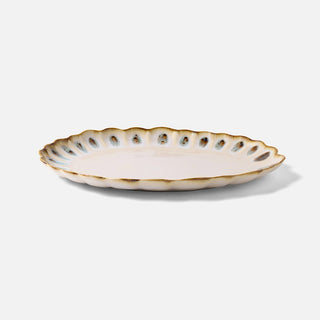 Decorative ceramic plate with scalloped edge on a light gray background