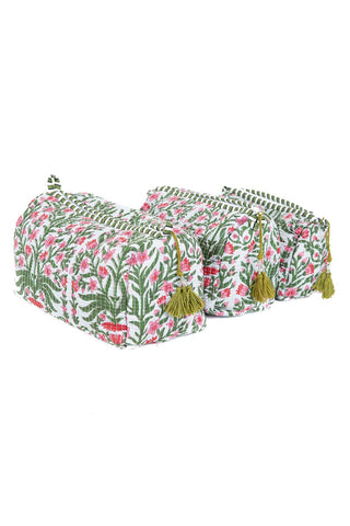 Set of three floral-patterned ottomans with tassels on a white background