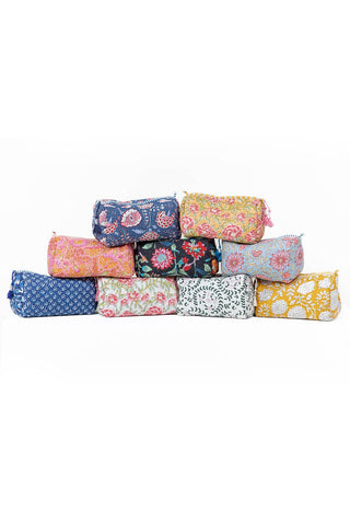 Stack of colorful fabric rolls with floral and polka dot patterns on a white background