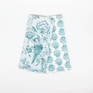 A folded seafoam green kitchen towel with a floral and bird pattern on it, displayed on a plain background.