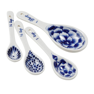 A set of four hand-painted ceramic measuring spoons in varying sizes, with blue floral patterns 