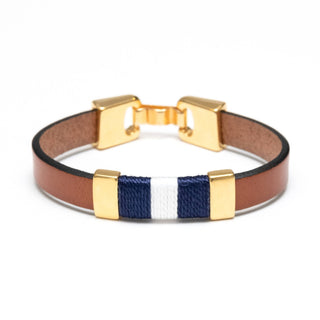Bracelet with brown leather strap, gold clasps, and blue and white ribbon section on a white background