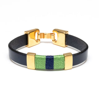A gold-tone metal bracelet with a black leather band and a central woven green and navy blue stripe detail, shown on a white background.