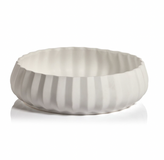 A large white ceramic serving bowl with modern scalloped edges