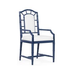 A Delia Armchair with a solid mahogany frame in a midnight blue color, featuring a Snow White linen cushion on the seat back and drop-in cushion