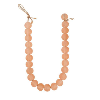 Garland with peach-colored beads on a white background