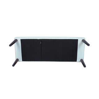 The underside of a modern upholstered bench or sofa, showing a black fabric seat panel, a central zipper, and four dark tapered legs on a plain white background.