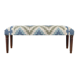 A rectangular upholstered bench with a geometric patterned fabric in shades of blue, sage green, and cream, supported by four dark brown wooden legs.