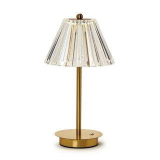 A gold base cordless table lamp with a clear acrylic shade makes a refined statement