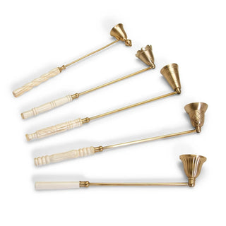 Set of six gold and white candle snuffers on a white background