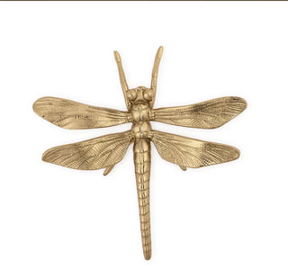 Gold dragonfly-shaped decorative item on a white background