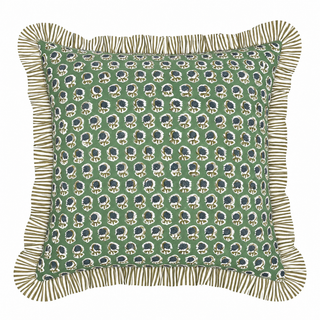 A square decorative throw pillow with a green background, featuring a repeating block-print style pattern of dark blue and cream motifs, finished with a striped fringed border.