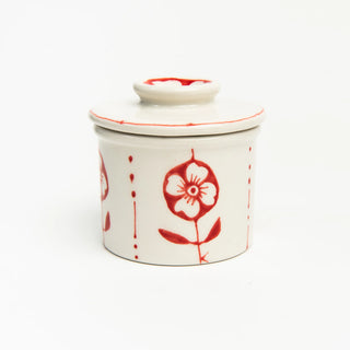 White ceramic butter crock with red floral patterns is hand-painted