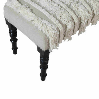 Beige textured throw blanket draped over a wooden stool with black legs on a white background