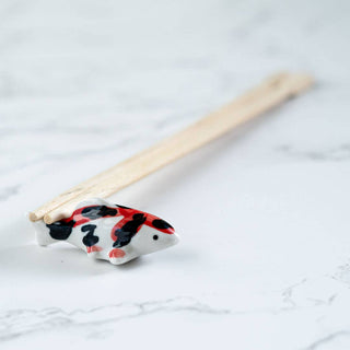 Decorative fish-shaped chopstick rest on a marble surface