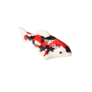Decorative fish figurine with red, black, and white pattern is a perfect rest for your chopsticks