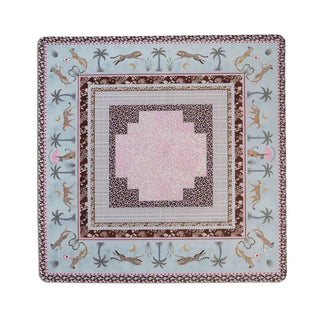 A square decorative mat with an intricate Southwestern-inspired pattern featuring jaguars, palm trees, and crescent moons on a light blue background, surrounded by brown and pink borders.