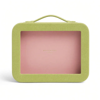 A rectangular makeup bag with a textured lime green fabric exterior, a top handle, and a clear window showing a pink interior. The brand name 'ADDISON HALL' is printed in gold on the pink interior.