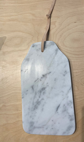 A marble cheese board equipped with a leather strap for hanging