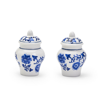 Two white ceramic jars with blue floral patterns on a white background