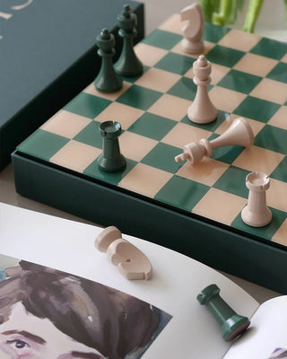 Chessboard with pieces on a table next to a photo of a person