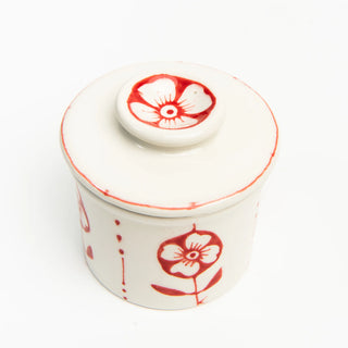 White ceramic French butter crock with red floral patterns 