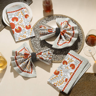 Decorative table setting with floral-patterned napkins on a beige surface.