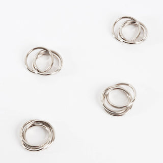 Set of four silver napkin rings on a white background