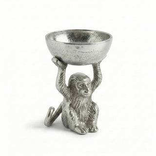 Decorative metal monkey holding a bowl on a white background