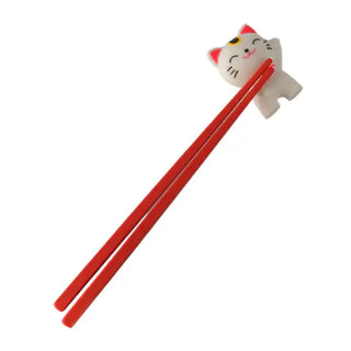Red chopsticks with a cat-shaped holder help you learn to use chopsticks