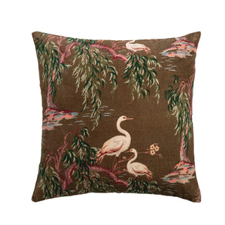 Decorative pillow with bird and foliage pattern on a brown background