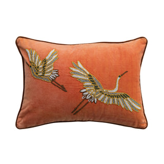 Decorative pillow with embroidered cranes on an orange background