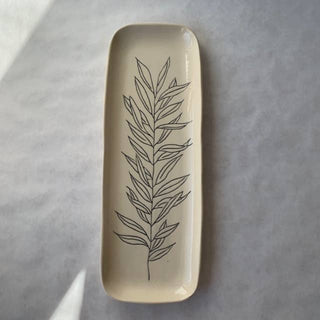 Rectangular ceramic dish with leaf design on a gray surface