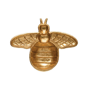 Gold bee-shaped decorative object on a white background