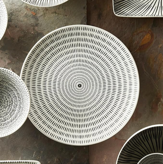 Decorative woven baskets with concentric circle pattern on a stone surface