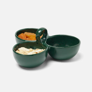 A three-compartment dark green ceramic snack bowl with a handle, shown on a light gray background with dried apricots and sliced almonds in the compartments.