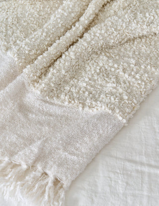 Close-up of a textured beige blanket on a white surface