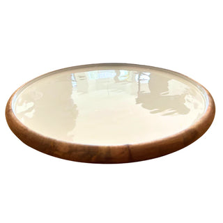 Round ceramic plate with wooden rim on a white background