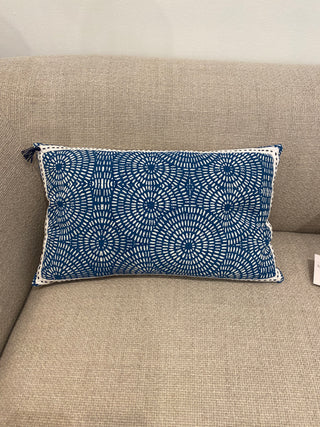 Blue circle patterned lumbar pillow on a beige couch