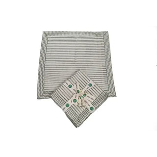 Set of four sage green hand block print cotton napkins with a decorative geometric pattern