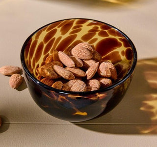 Glass bowl with tortoise pattern filled with almonds 